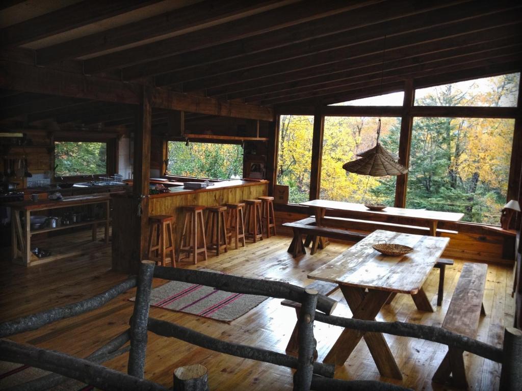 a log cabin with a table and a bar at Onai Hostel in Las Trancas