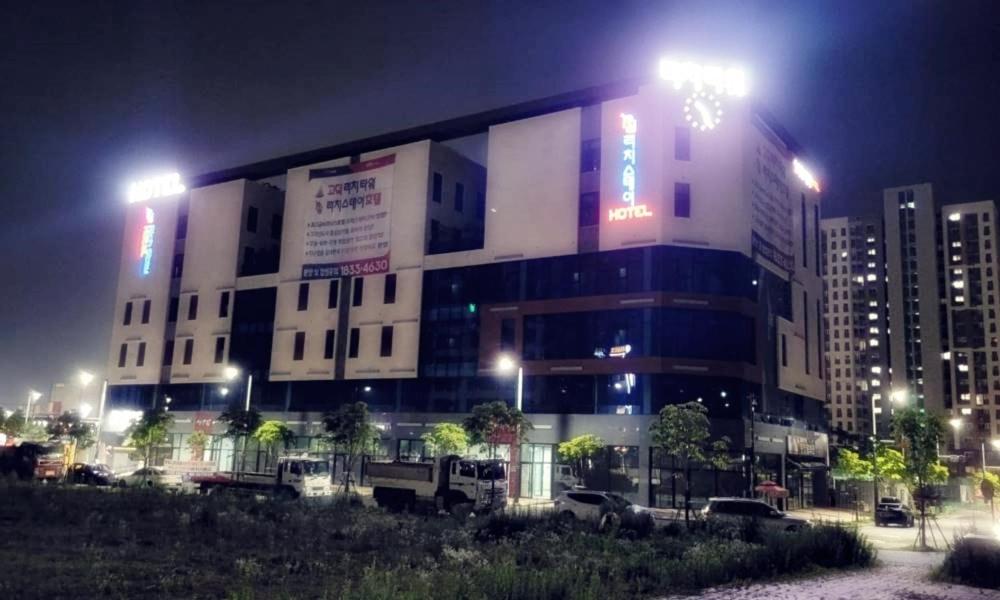 un bâtiment la nuit avec des voitures garées devant lui dans l'établissement Pyeongtaek Godeok Rich Stay Hotel, à Pyeongtaek