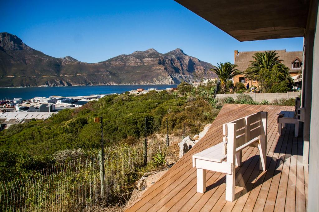 a white bench sitting on a deck overlooking the water at Best Place Ever in Hout Bay