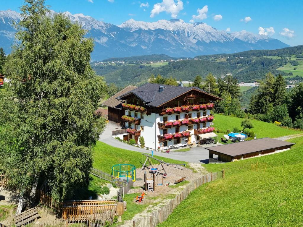 eine Luftansicht eines Hauses mit Bergen im Hintergrund in der Unterkunft Appartment Sattlerhof in Mutters