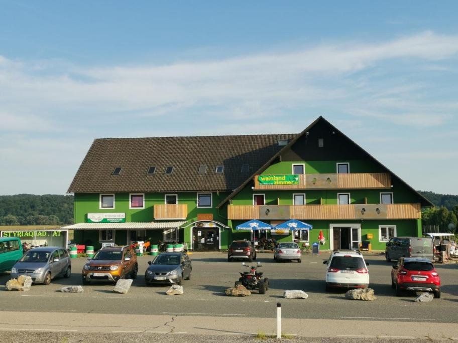 a large building with cars parked in front of it at Weinlandzimmer in Hengsberg