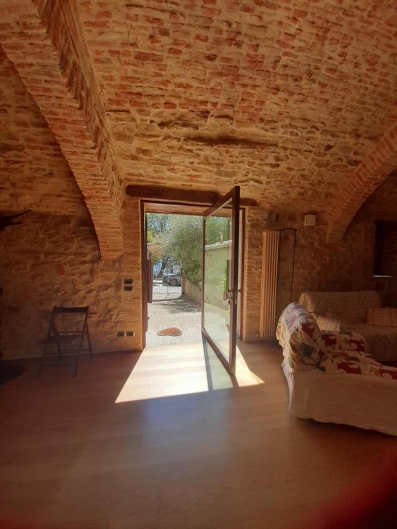 een kamer met een grote glazen deur in een bakstenen muur bij "Il Pollaio" guests house in Panicale