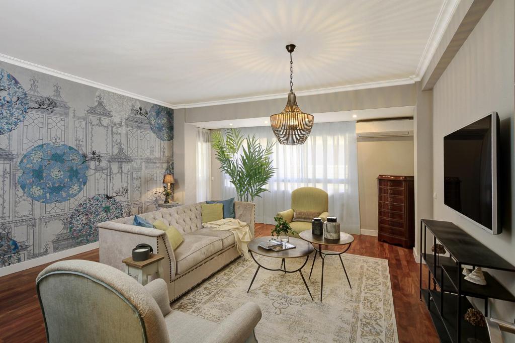 uma sala de estar com um sofá e uma televisão em Living4Malaga Soho Orangerie Deluxe em Málaga