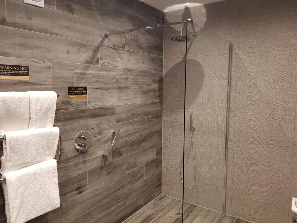 a bathroom with a shower with a glass door at The Inn on Loch Lomond in Luss