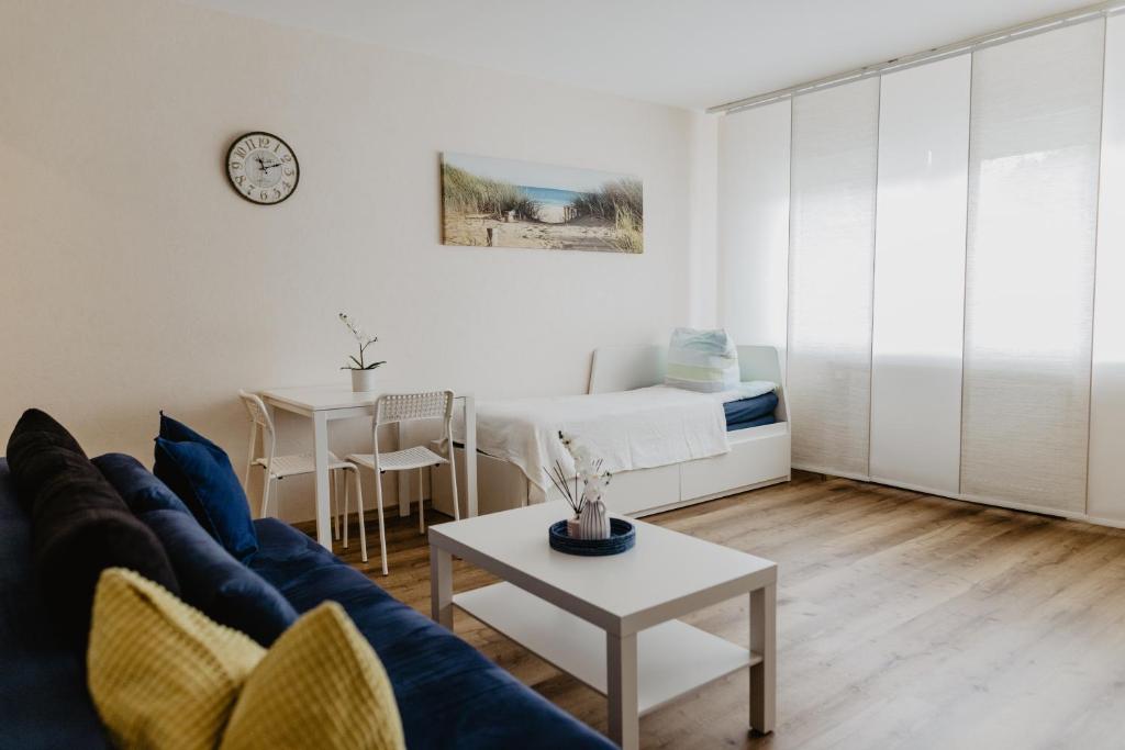 uma sala de estar com um sofá azul e uma mesa em SK Apartments - Sandwood em Gelsenkirchen