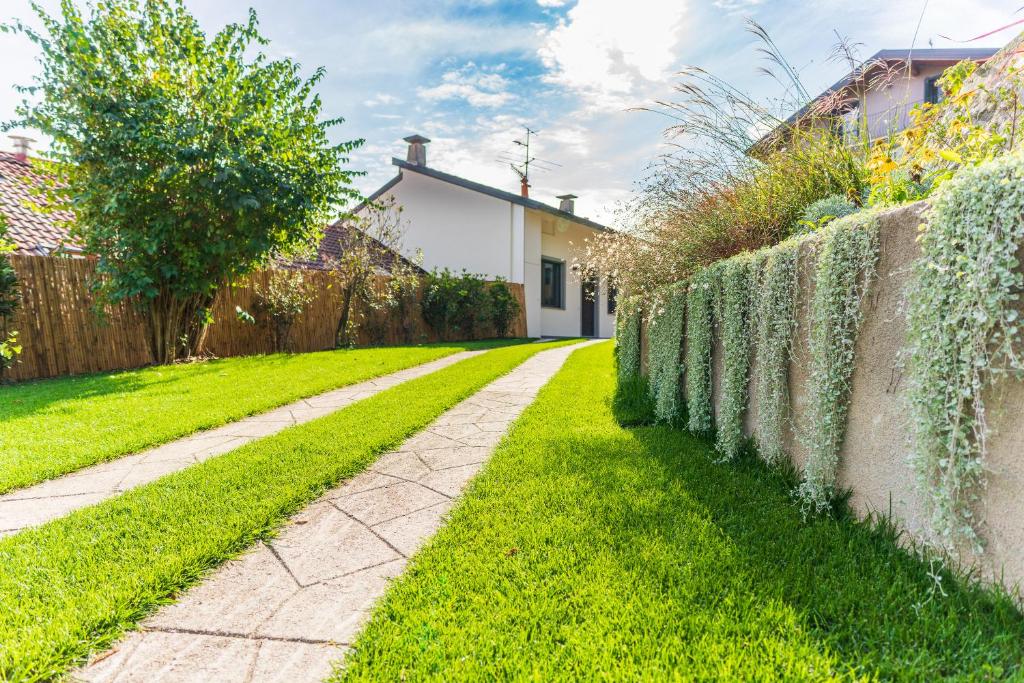 um jardim com uma parede de retenção e um passeio em Dimensione Armonica - Elegance and comfort among lakes and hills em Comabbio