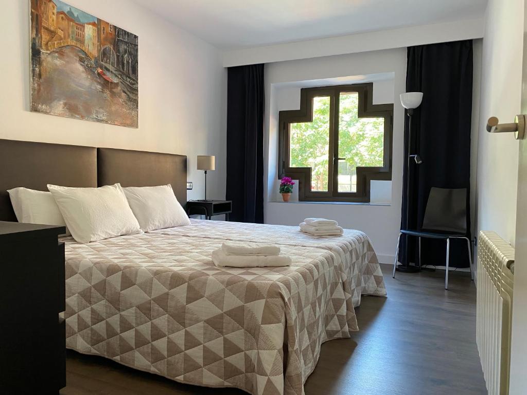 a bedroom with a bed with two towels on it at LC Apartamentos César Augusto in Zaragoza