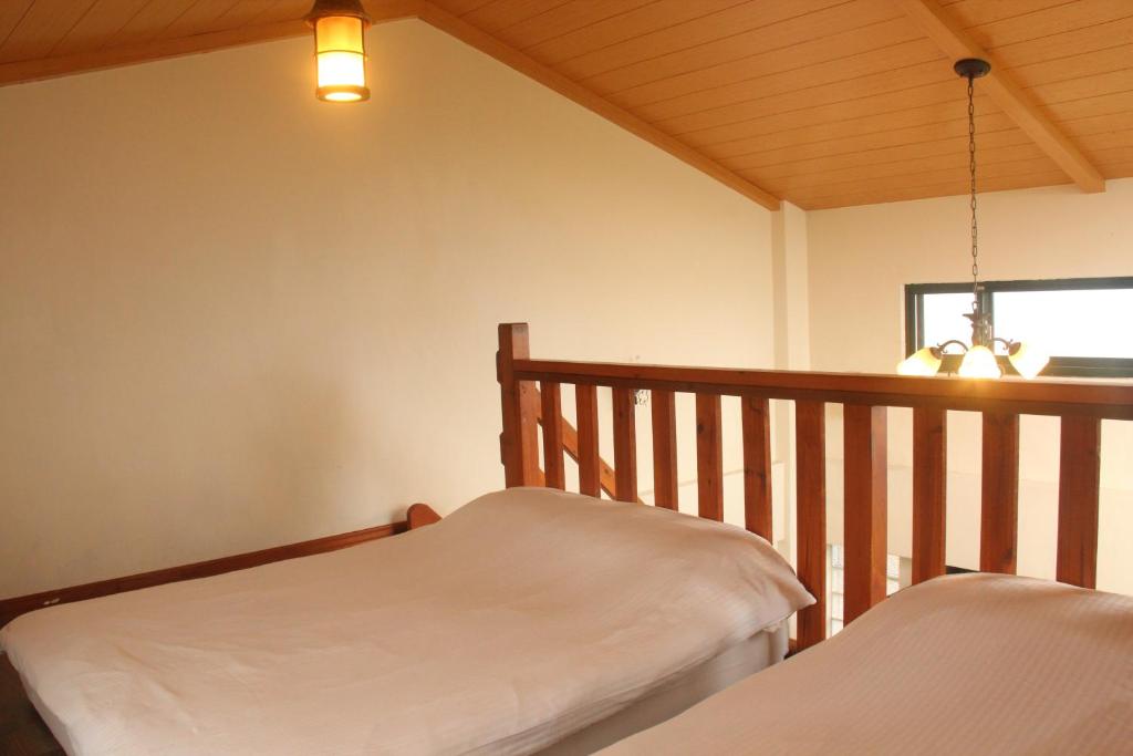 a bedroom with two beds and a wooden railing at Emmanuel Farm House in Ren&#39;ai