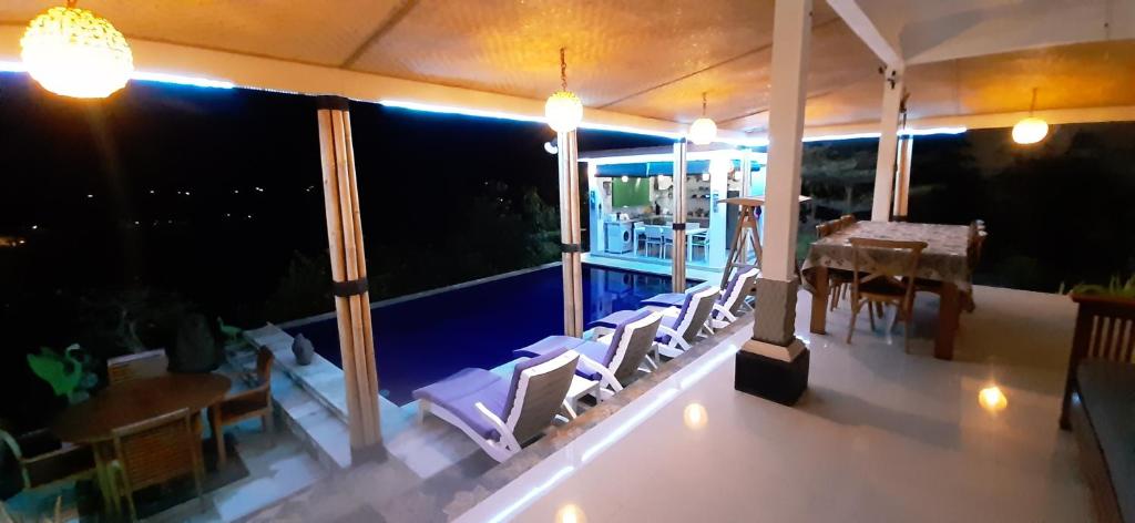 a house with a balcony with a table and chairs at Cantik Villa in Lovina