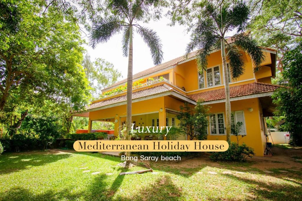 バンサレーにある300m from beach - Luxury Mediterranean Holiday House - Pets Welcomeのヤシの木が目の前に広がる黄色い家