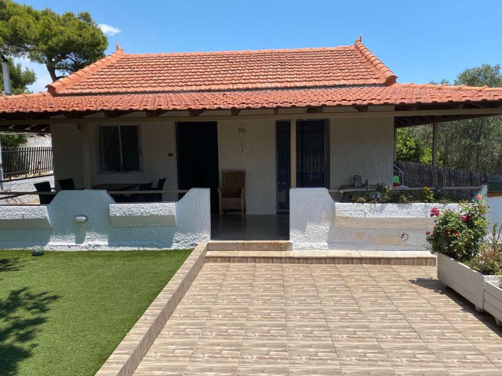 una pequeña casa blanca con techo rojo en La casa de PortoRafti, en Porto Rafti