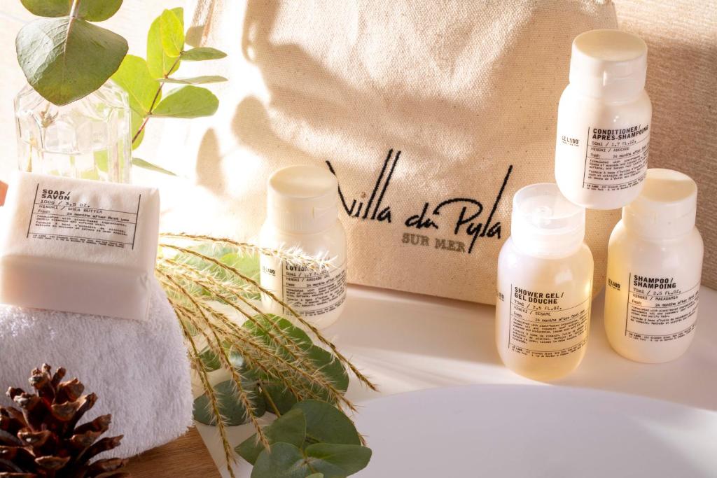 a table with several bottles of moisturizing products on it at Villa du Pyla in Pyla-sur-Mer