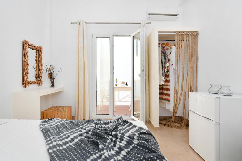 a white bedroom with a bed and a mirror at Sandaya Living - M Apartment in Naousa
