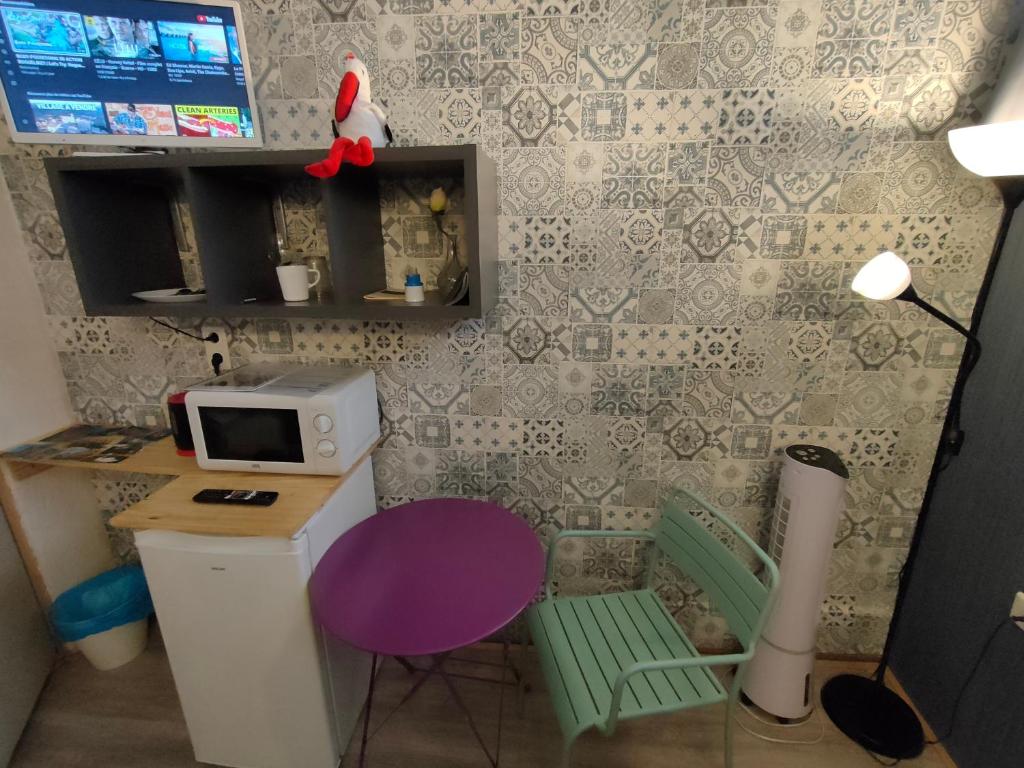 eine kleine Küche mit einem Tisch und einer Mikrowelle in der Unterkunft La Provence Studio in Colmar