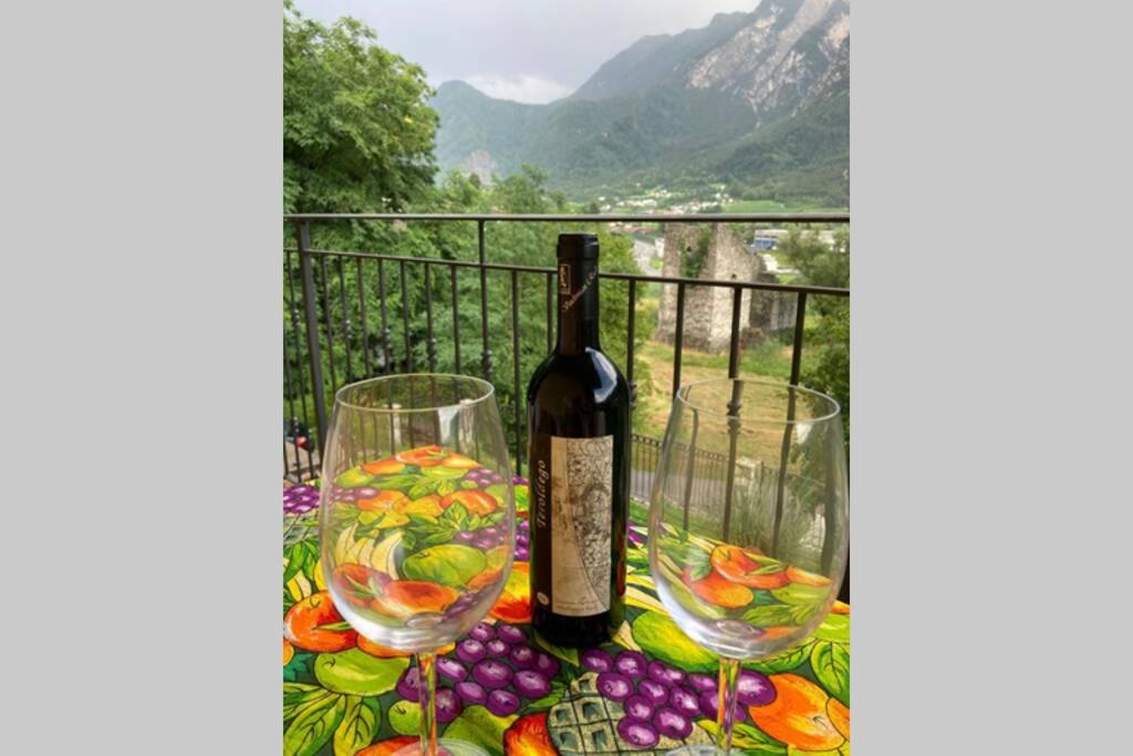 a bottle of wine sitting on a table with two glasses at Appartamento alla vecchia torre in Novaledo