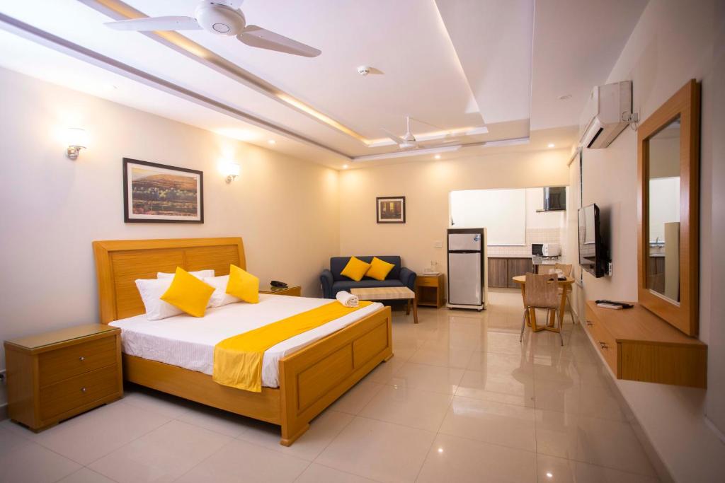 a bedroom with a bed and a living room at Maati Spaces - Studio Apartments in Lahore