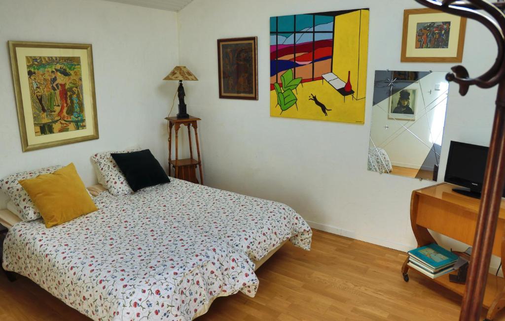 1 dormitorio con 1 cama y pinturas en la pared en les coquilles, en Lanton
