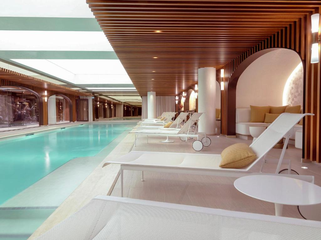 a hotel pool with lounge chairs and a swimming pool at Hôtel D'Aubusson in Paris