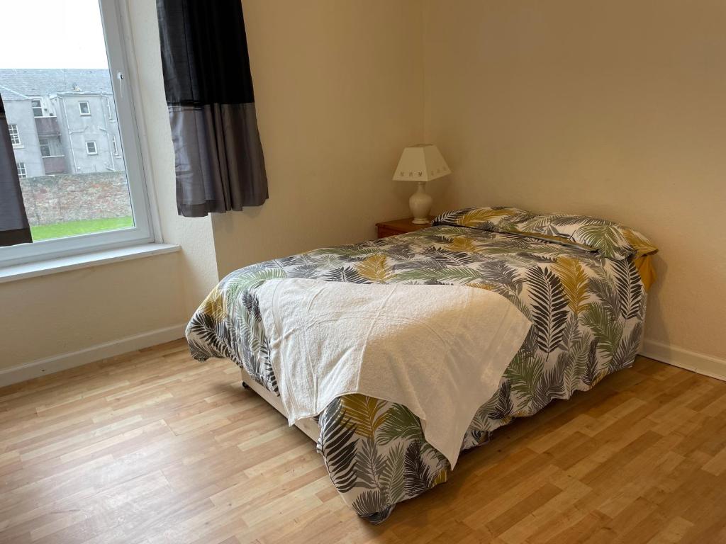 a bedroom with a bed and a window at Rainforest 1 in Campbeltown