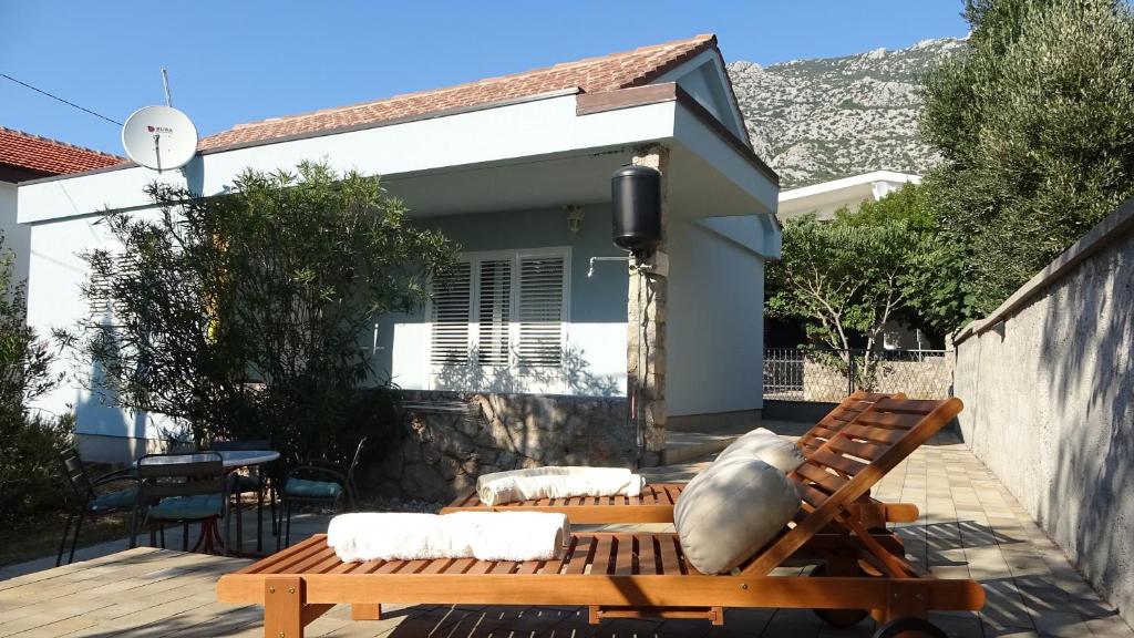 a patio with a bench and a house at 35 meters from sea Sweat house with garden in Karlobag