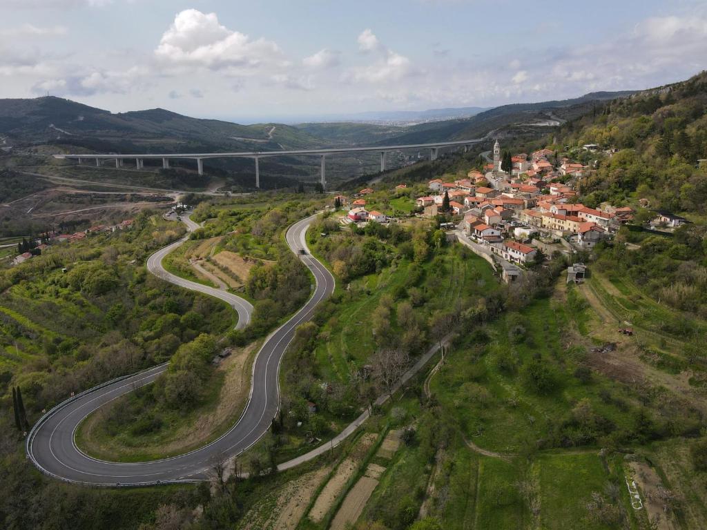 Luftblick auf eine kurvenreiche Straße in einem Dorf in der Unterkunft Apartment Beautiful Črni Kal in Črni Kal