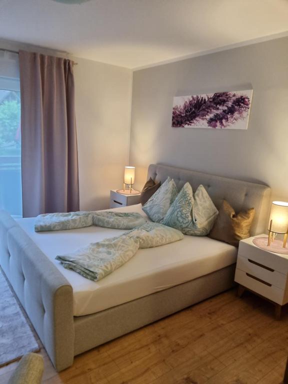 a bedroom with a large bed with two lamps on it at Alpe-Adria Apartments Chanel top12 in Oberaichwald