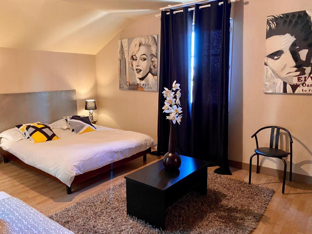 una camera con due letti, un tavolo e una sedia di LE HAVANA-Maison d'hotes a Bergerac
