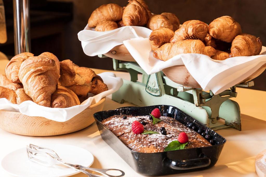 a table topped with pastries and a plate of bread at Superior Hotel Tirolerhof - Zell am See in Zell am See