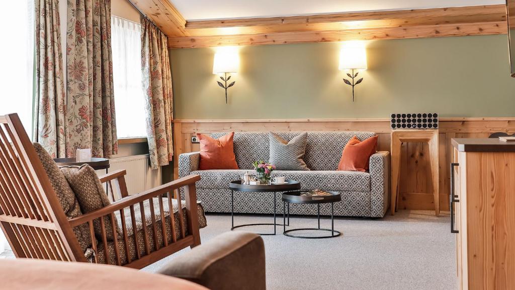 a living room with a couch and a table at Superior Hotel Tirolerhof - Zell am See in Zell am See
