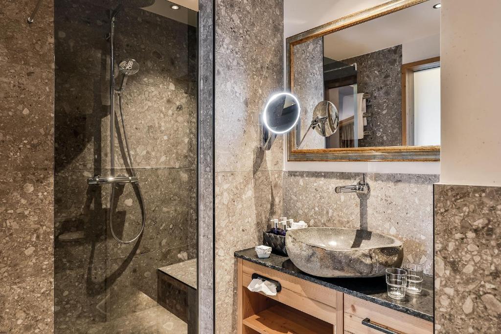 a bathroom with a sink and a shower at Superior Hotel Tirolerhof - Zell am See in Zell am See