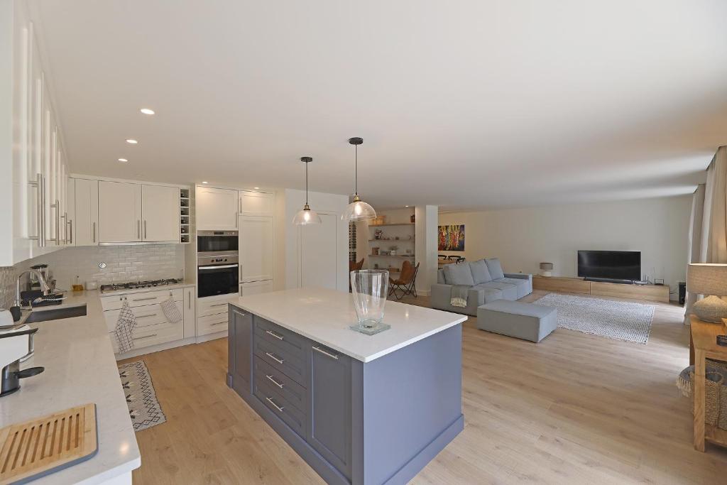 a large kitchen and living room with white cabinets at FLH Serralves House with Garden in Porto