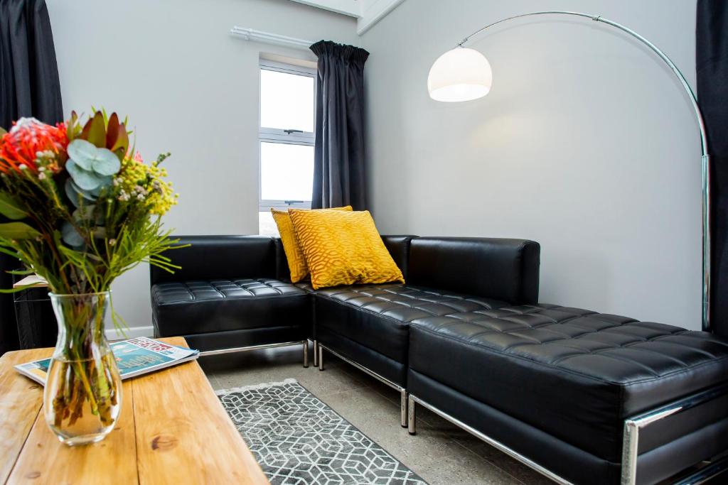 a black leather couch in a living room with a table at MATIPA-OMEMMA in East London