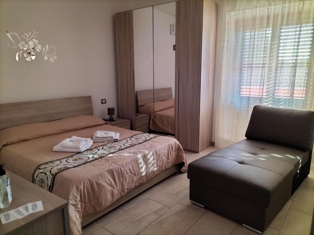 een hotelkamer met 2 bedden en een stoel bij B&b la Fenice in Terralba