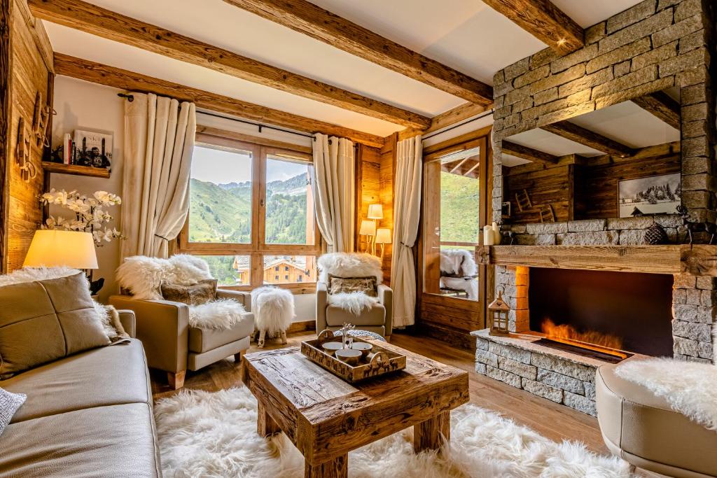 a living room with a couch and a fireplace at Arc 1950, ambiance chalet luxe 5/7pers dans résidence 5* skis aux pieds avec SPA in Arc 1950