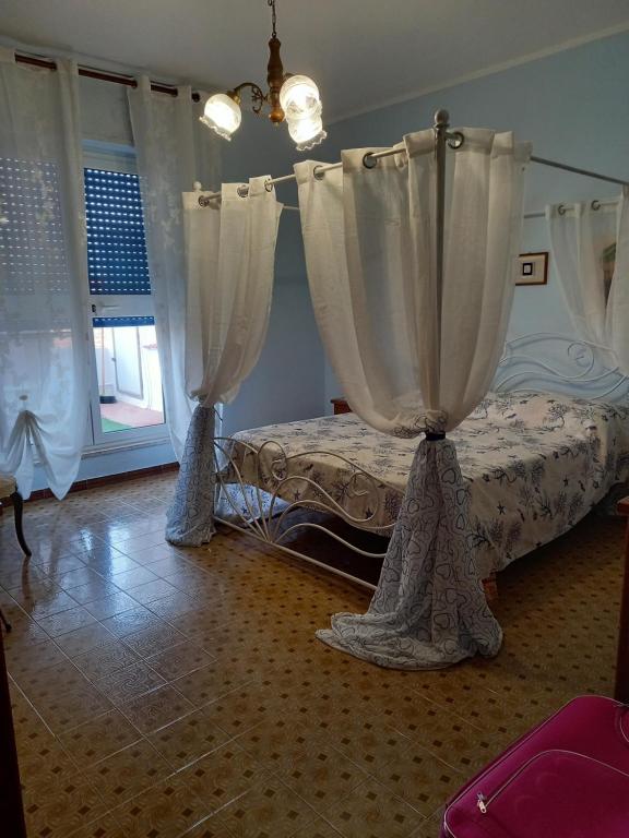 Un dormitorio con una cama con cortinas. en Casa Blu oltremare, en SantʼAntìoco