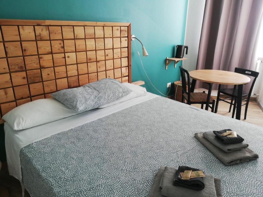 Schlafzimmer mit einem Bett und einem Tisch mit Stühlen in der Unterkunft La Cordata Accommodation - Hotel Woodhouse in Cinisello Balsamo