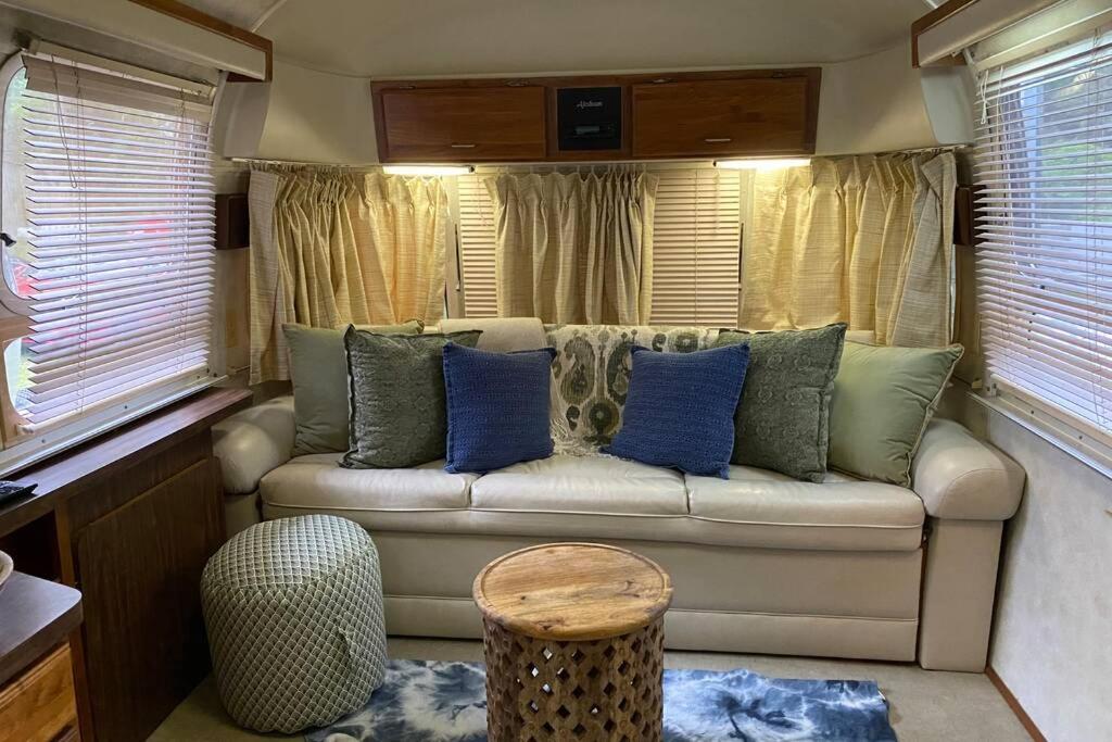ein Wohnzimmer mit einem Sofa und blauen Kissen in der Unterkunft Beautiful Airstream, Beaufort SC-Enjoy the Journey in Beaufort