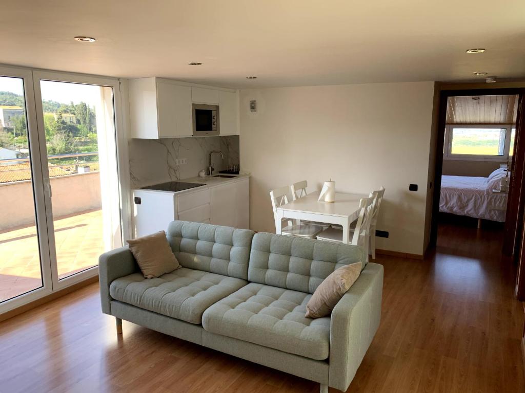 een woonkamer met een bank en een keuken bij Apartamento entero con vistas panorámicas in Avinyonet