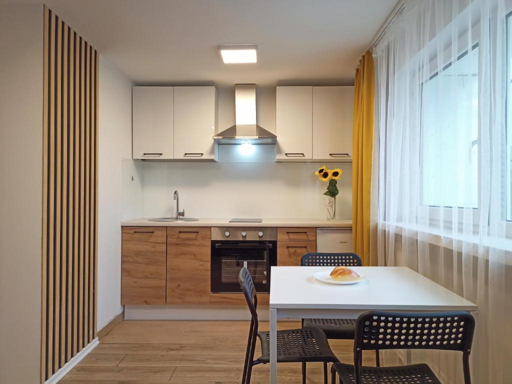 a kitchen with a table and chairs and a window at Apartamenty W Domu in Białystok