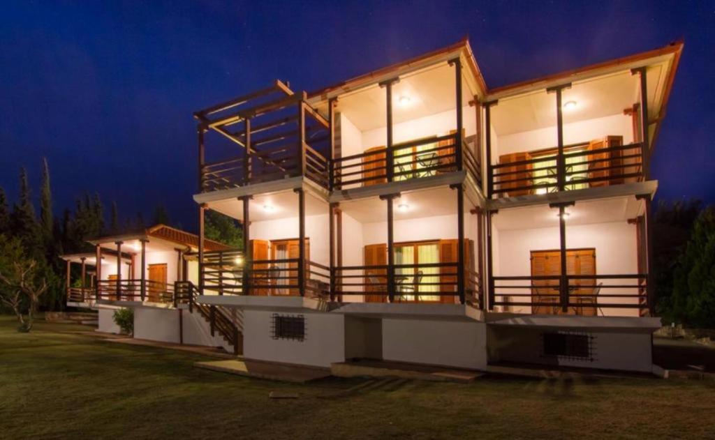 a large white house with balconies at night at Roxani Country House Resort in Maronia