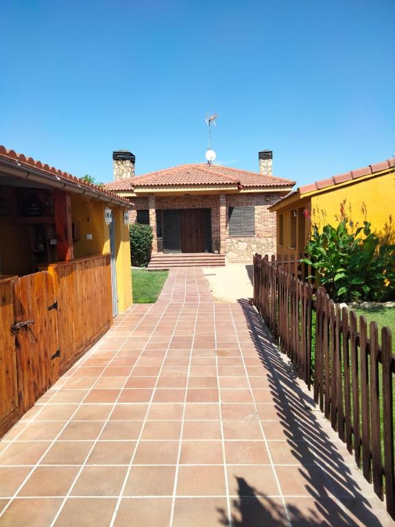 a walkway leading to a house with a fence at La Casa del Colmao in Ávila
