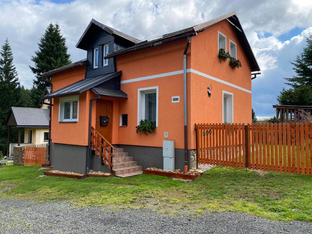 a house with a fence in front of it at Chalupa U kočky in Kovářská