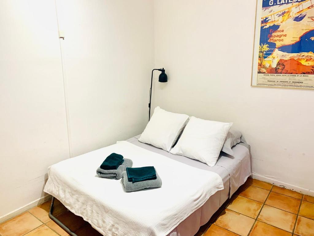 a bedroom with a bed with two towels on it at Studio des Carmes in Toulouse