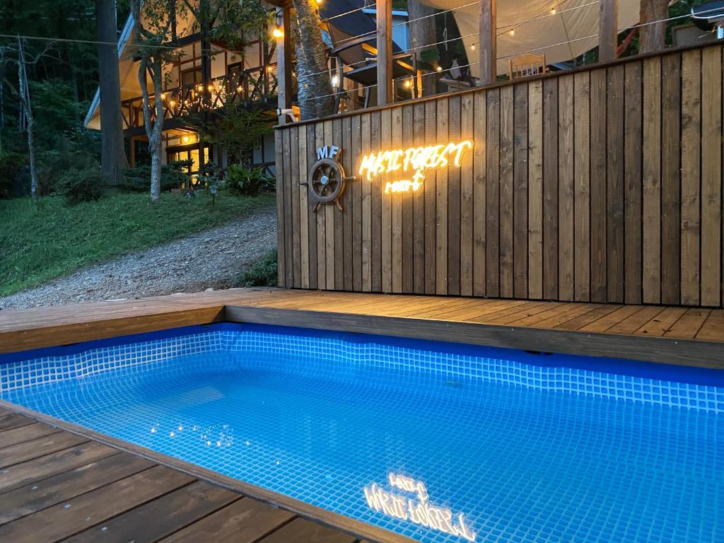 een zwembad naast een houten hek bij MUSIC FOREST Villa&Camp in Sasayama