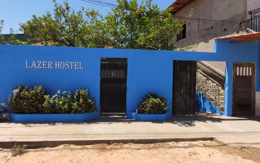 una casa blu con due piante davanti di Lazer Hostel a Barreirinhas