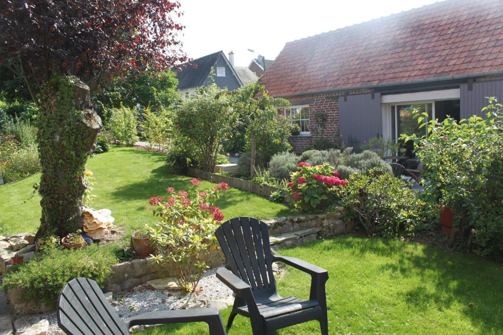 twee stoelen in een tuin met een tuin bij Chambres d'hôtes L'Aubaine avec jacuzzi in Wanquetin