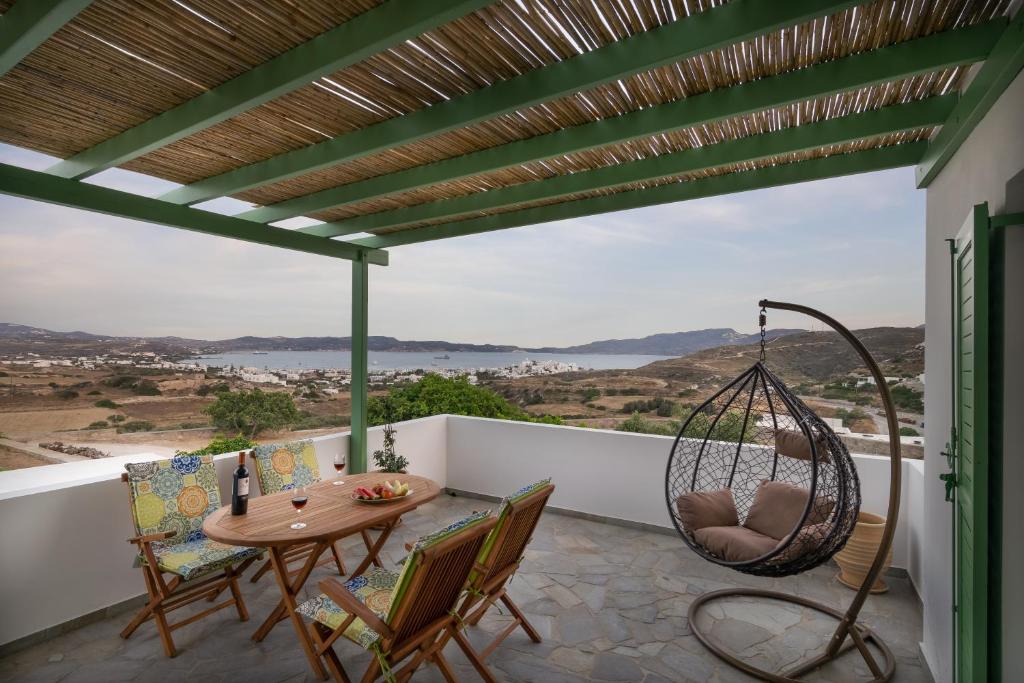 d'une terrasse avec une table, des chaises et une balançoire. dans l'établissement Vitalis Residences - Rural Living, à Péran Triovasálos
