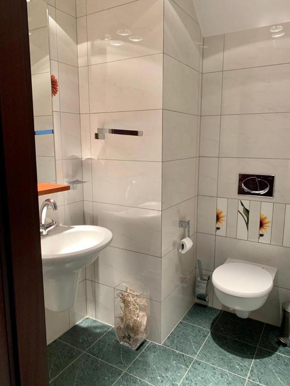 Łazienka z białą toaletą i umywalką w obiekcie Apartament Panorama Ustronia w Ustroniu