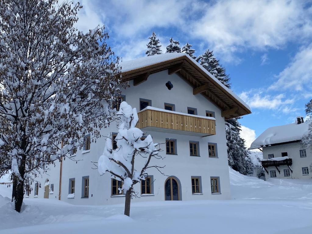 a building covered in snow with trees in the foreground at Chalet SILVER FOX - Luxus Chalets in Sankt Anton am Arlberg