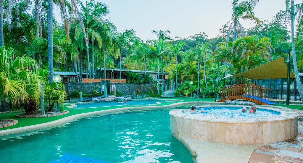 uma piscina num resort com pessoas em The Palms At Avoca em Avoca Beach